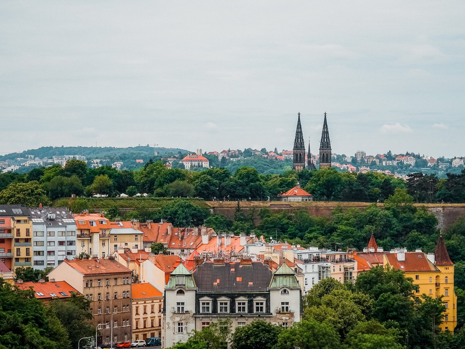 Věže baziliky svatého Petra a Pavla a vyšehradské hradby nad střechami Podolí